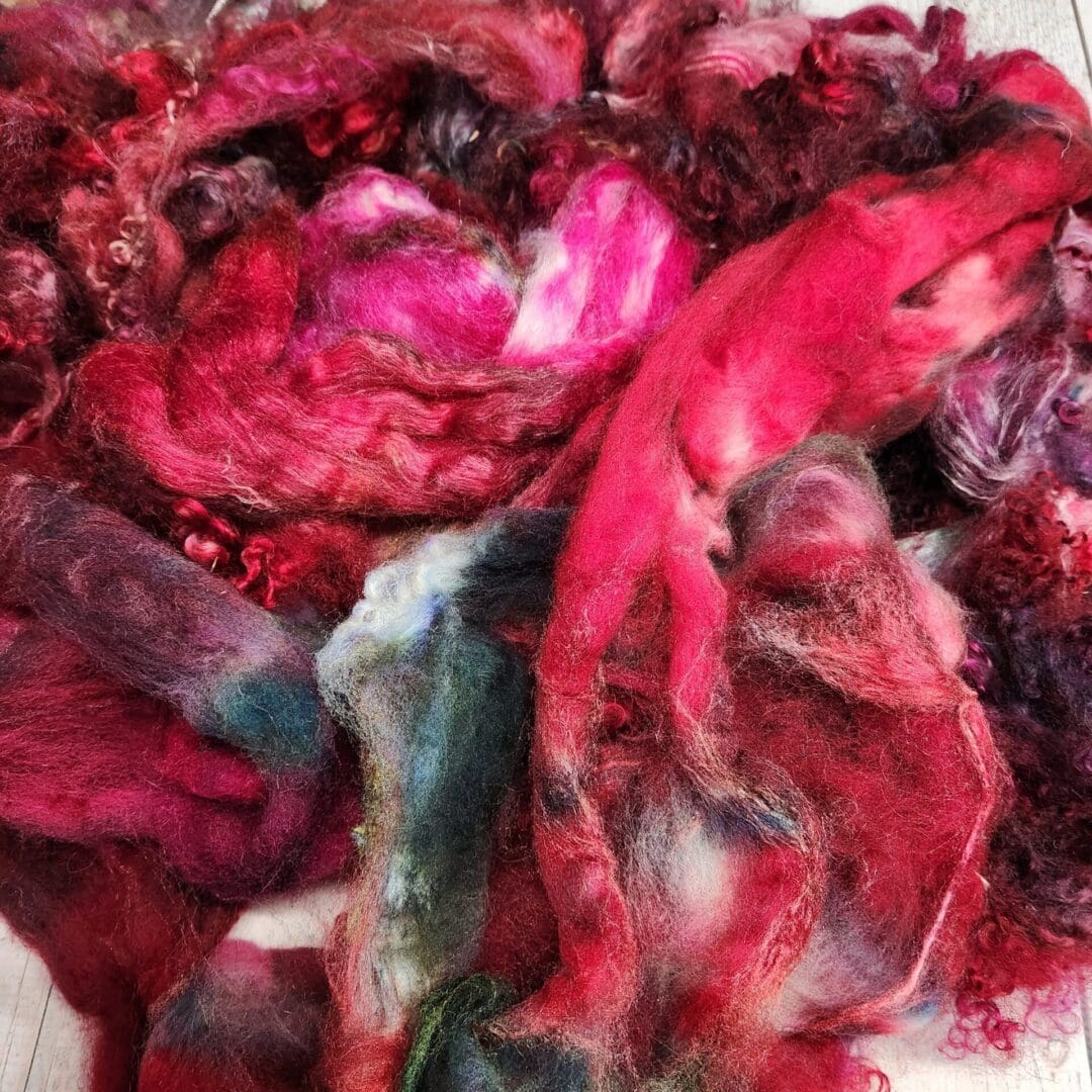 Pile of red, pink, and blue fiber.