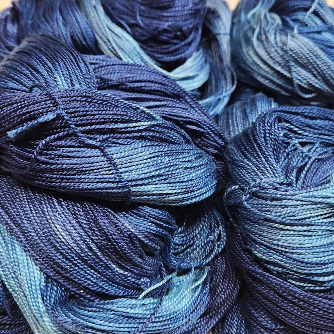 Skeins of blue dyed yarn on a table.