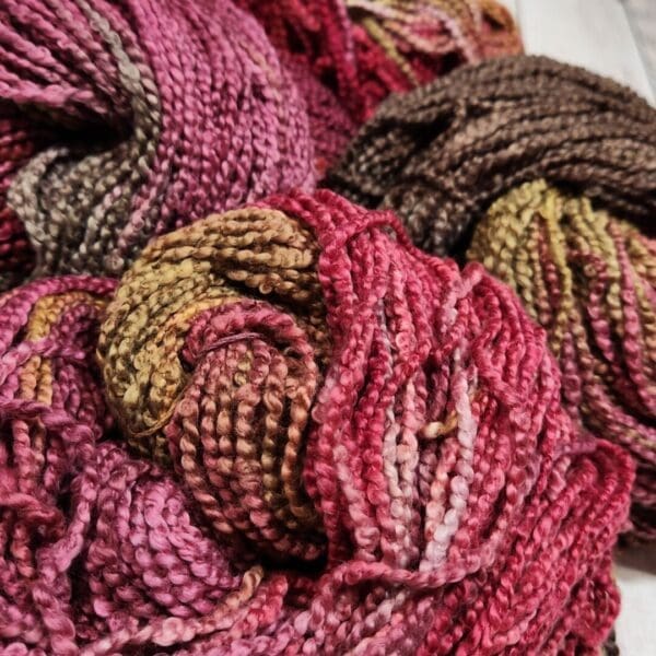 Three skeins of yarn in a variety of colors.