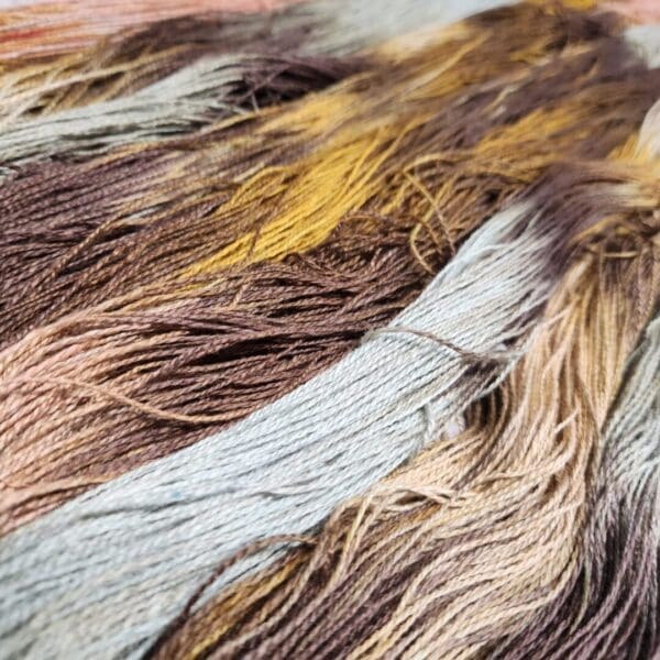 A close up of a bunch of different colored yarns.