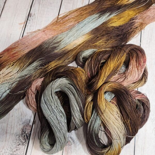 Two skeins of yarn on a wooden table.