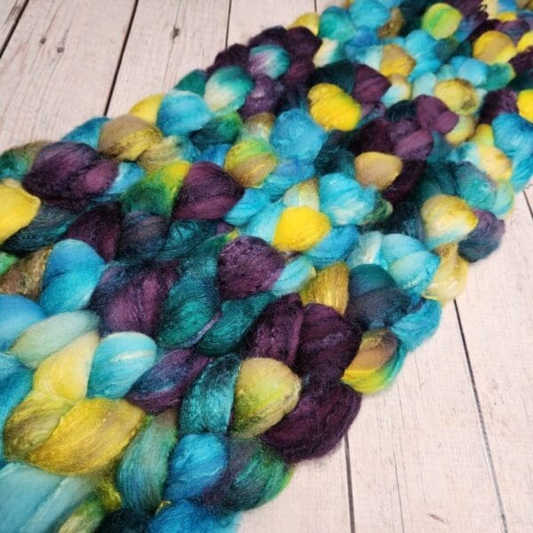 Purple, blue, yellow and green merino wool roving.