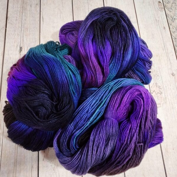 Purple, blue and black skeins of yarn.
