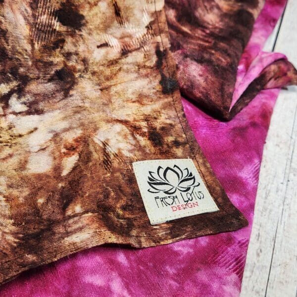 20231218_145815 A brown and pink tie dyed towel with a label on it.