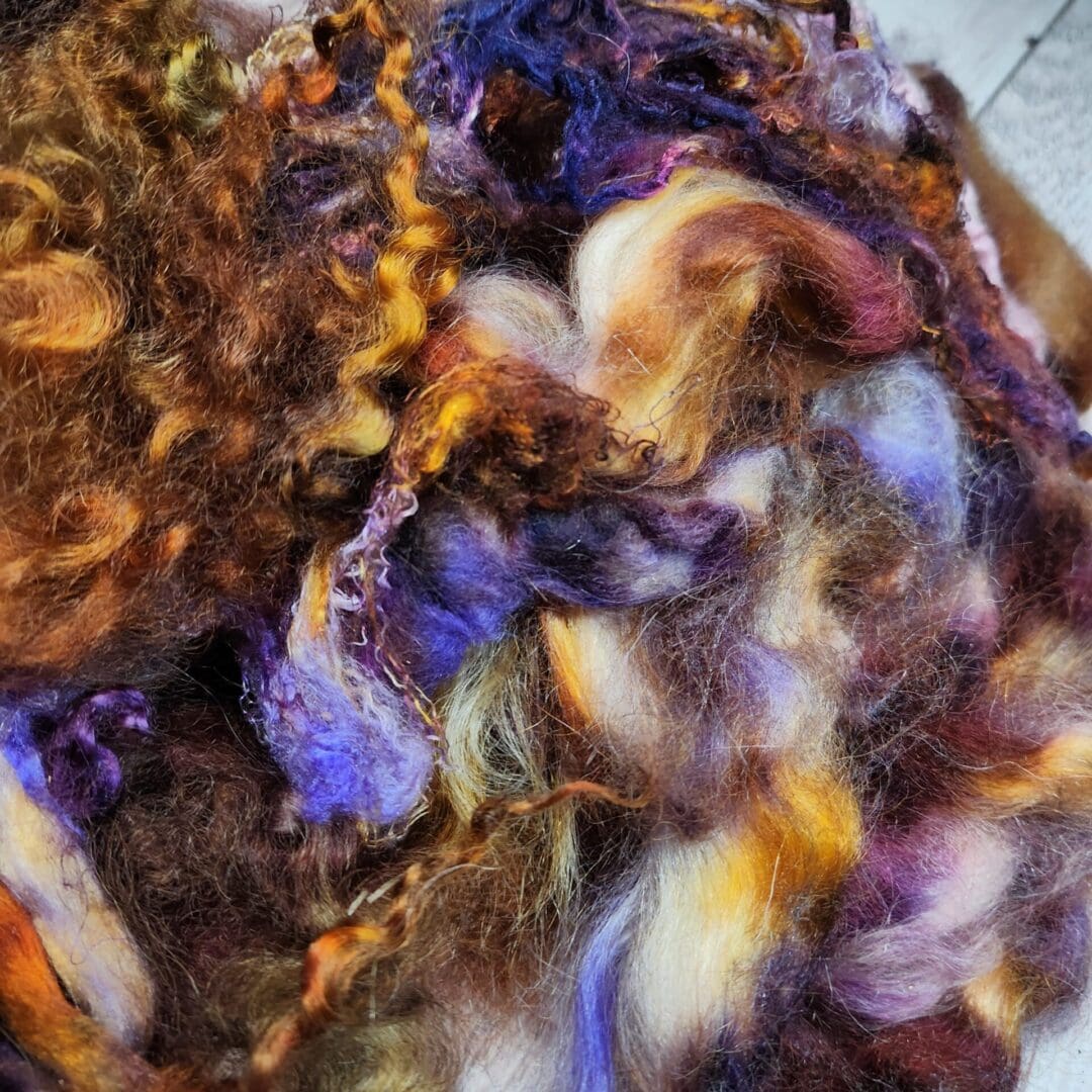 Purple, brown, and gold wool fibers.