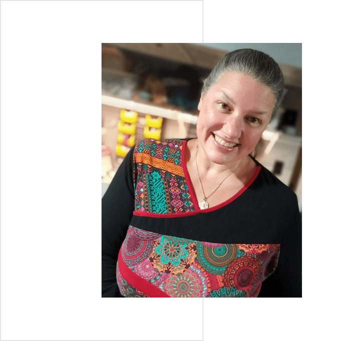 Julie Benac A woman is smiling in front of a fresh kitchen.